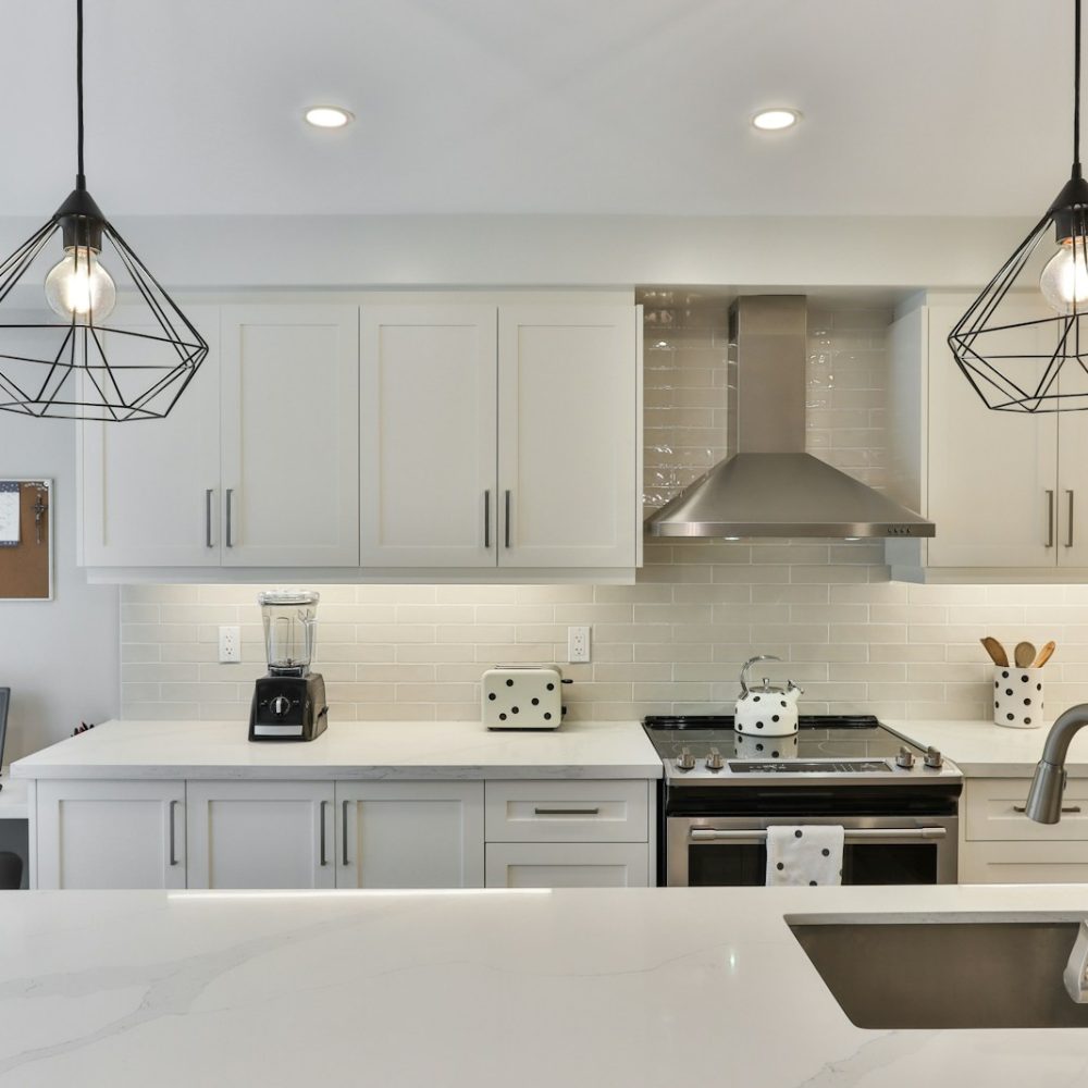 white wooden kitchen cabinet with black pendant lamp